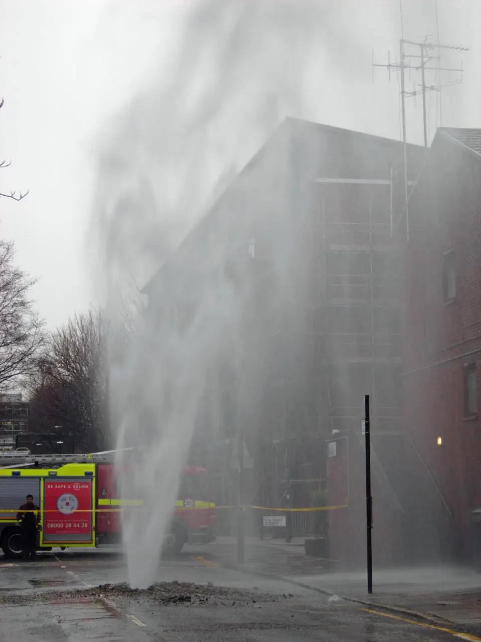 Water from a burst water main flooding a London street