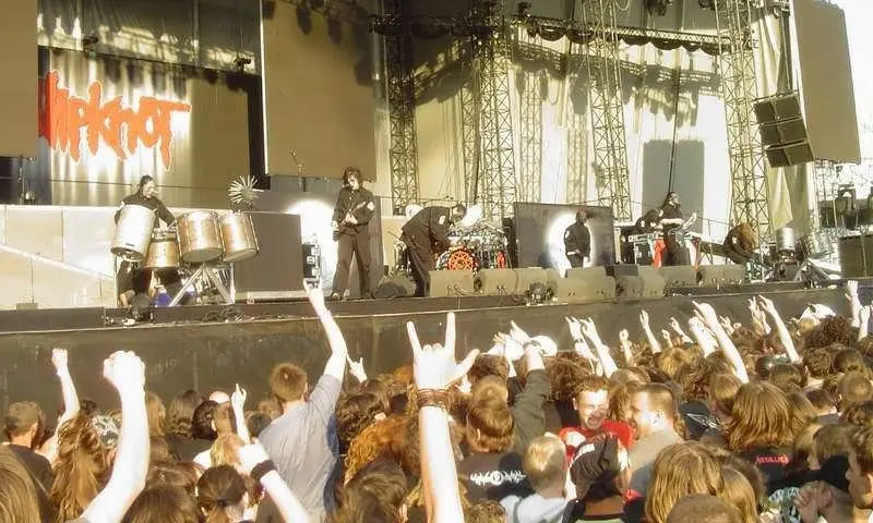 Slipknot performing live on stage in front of a cheering crowd