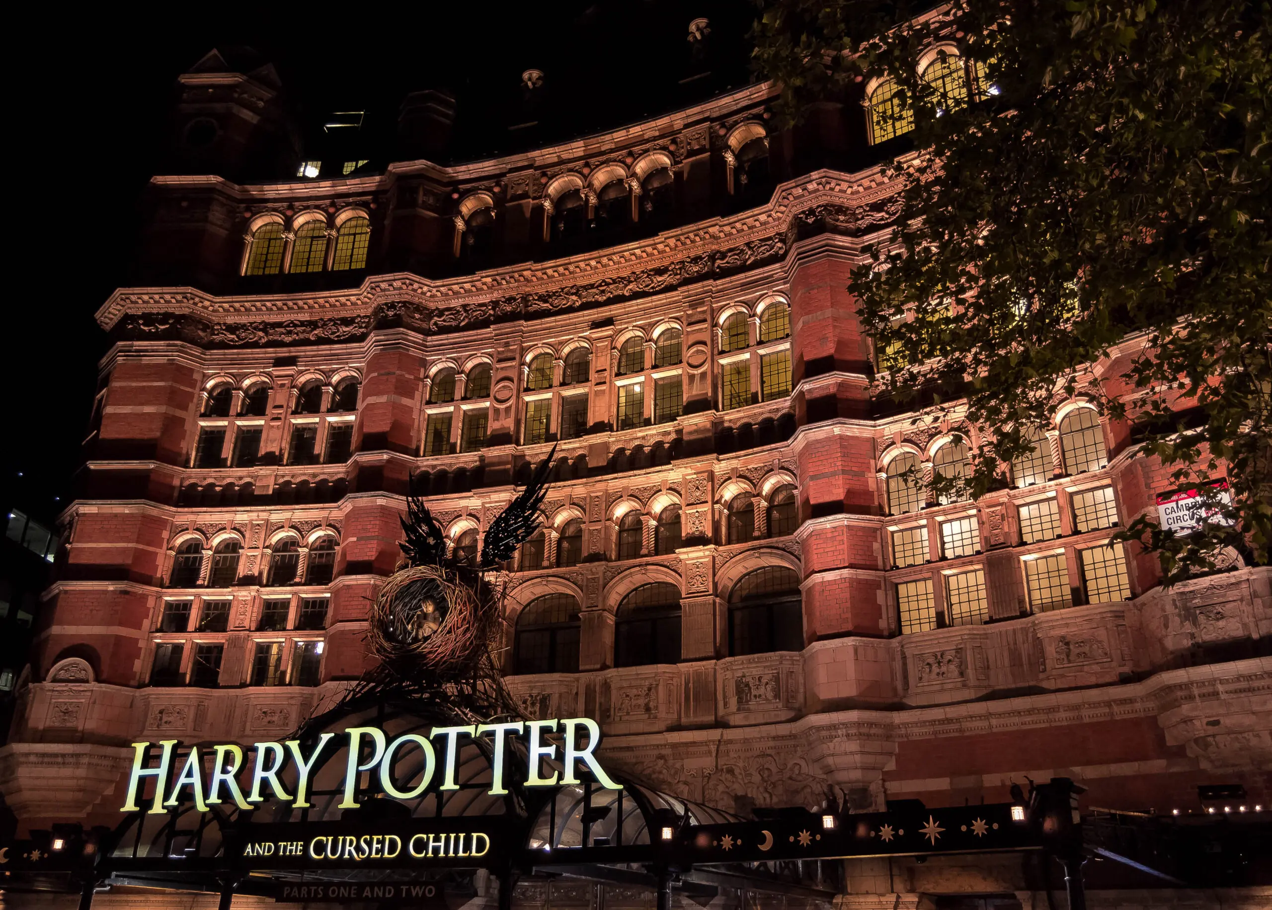 The Palace Theatre in London lit up at night with the Harry Potter and the Cursed Child sign