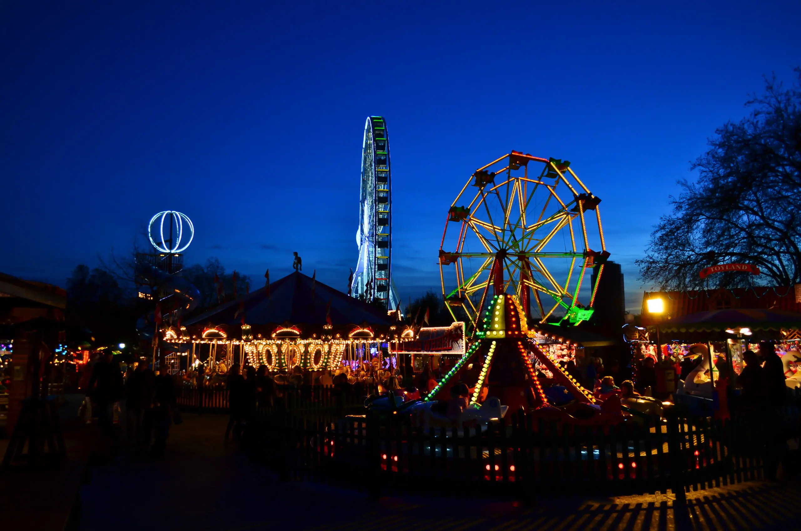 Illuminated fairground rides at Winter Wonderland in Hyde Park, London, at night