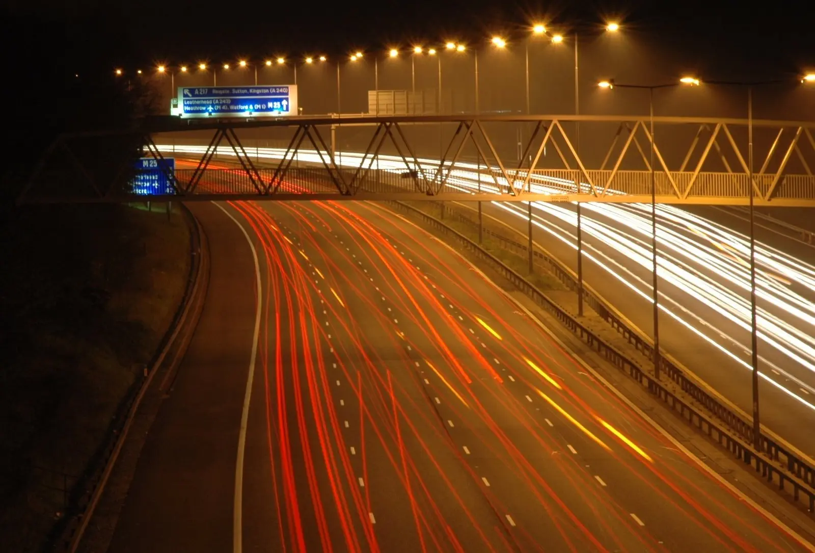 M25 motorway at night with light trails from traffic on the London Orbital